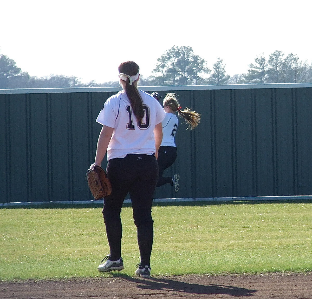 Image: Shortstop Paige Westbrook(10) admires the hustle of teammate Madison Washington(2) who sprints toward the wall and makes the over-the-shoulder catch for Italy.