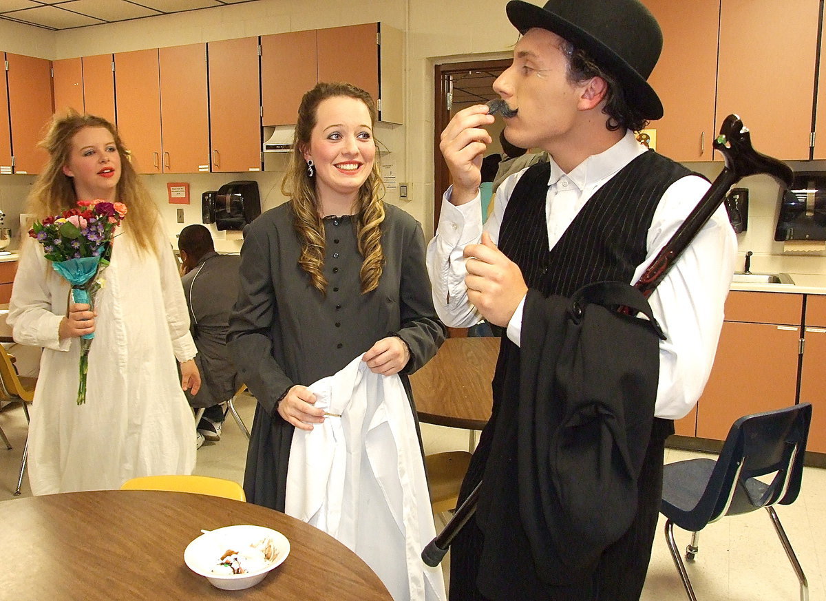 Image: Chace McGinnis, or “Pantalone,” removes his disguise very carefully as Tia Russell and Maddie Pittman wait for the scream.