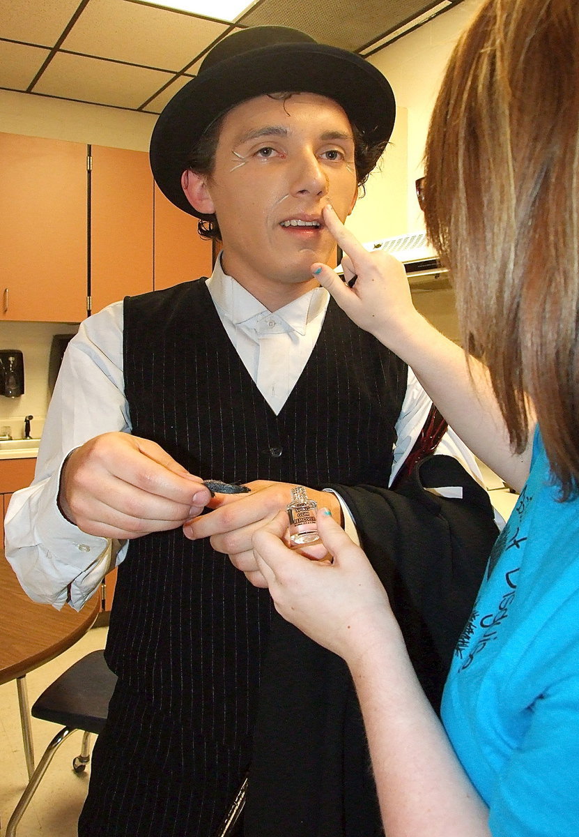 Image: Crew member Emily Stiles helps Chace McGinnis remove the mustache by applying glue remover.