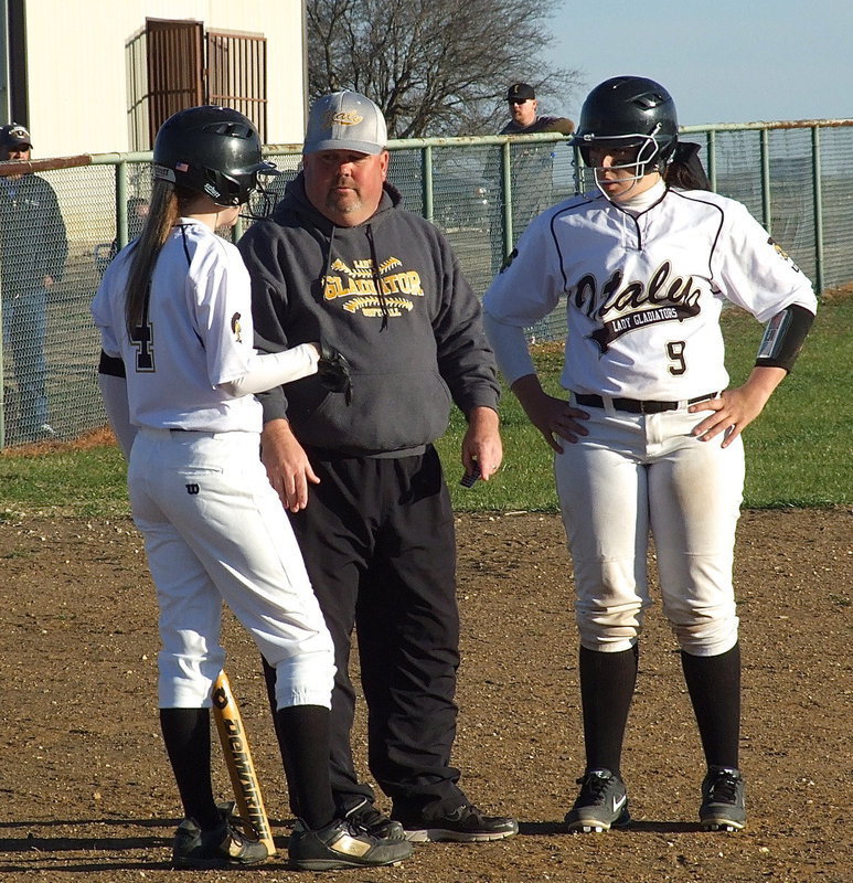 Image: Lady Gladiator head coach Wayne Rowe covers the base-ics with Kelsey Nelson(4) and Alyssa Richards(9).