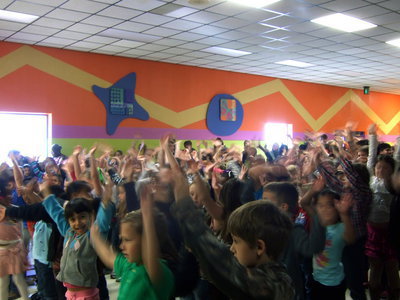 Image: Stafford students enthusiastically sing along with the choir—hand motions and all!