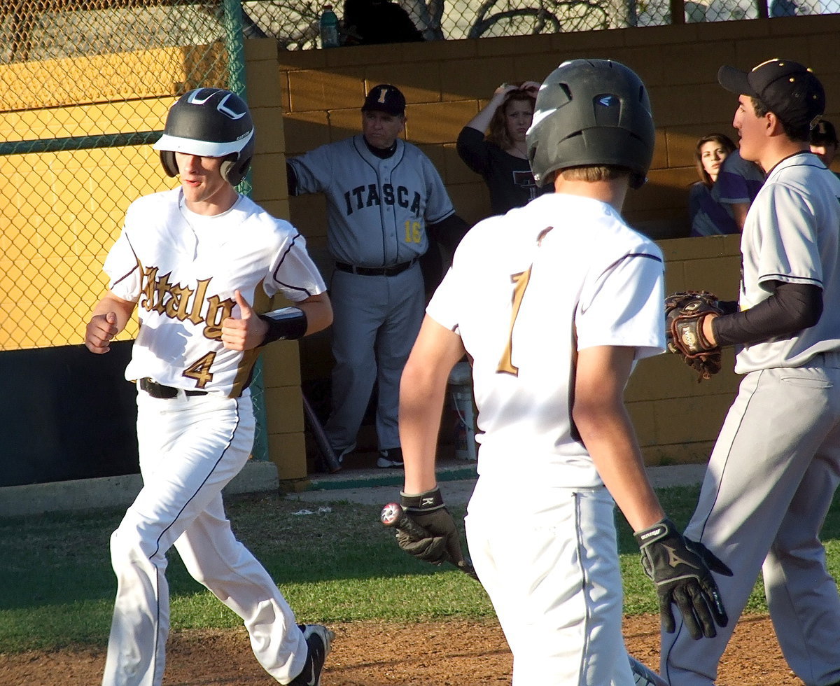 Image: In runs Justin Wood(4) from third-base with teammate Levi McBride(1) battling at the plate.