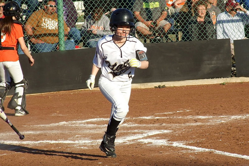 Image: Tara Wallis(5) scampers to first base after earning a walk at the plate.