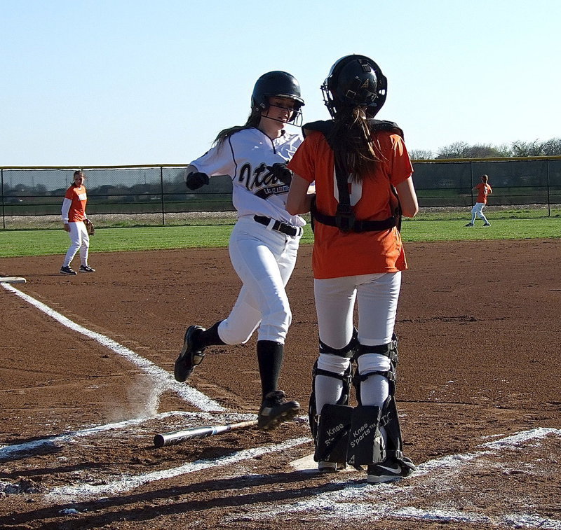 Image: Kelsey Nelson(14) races home to score a run for the Lady Gladiators.