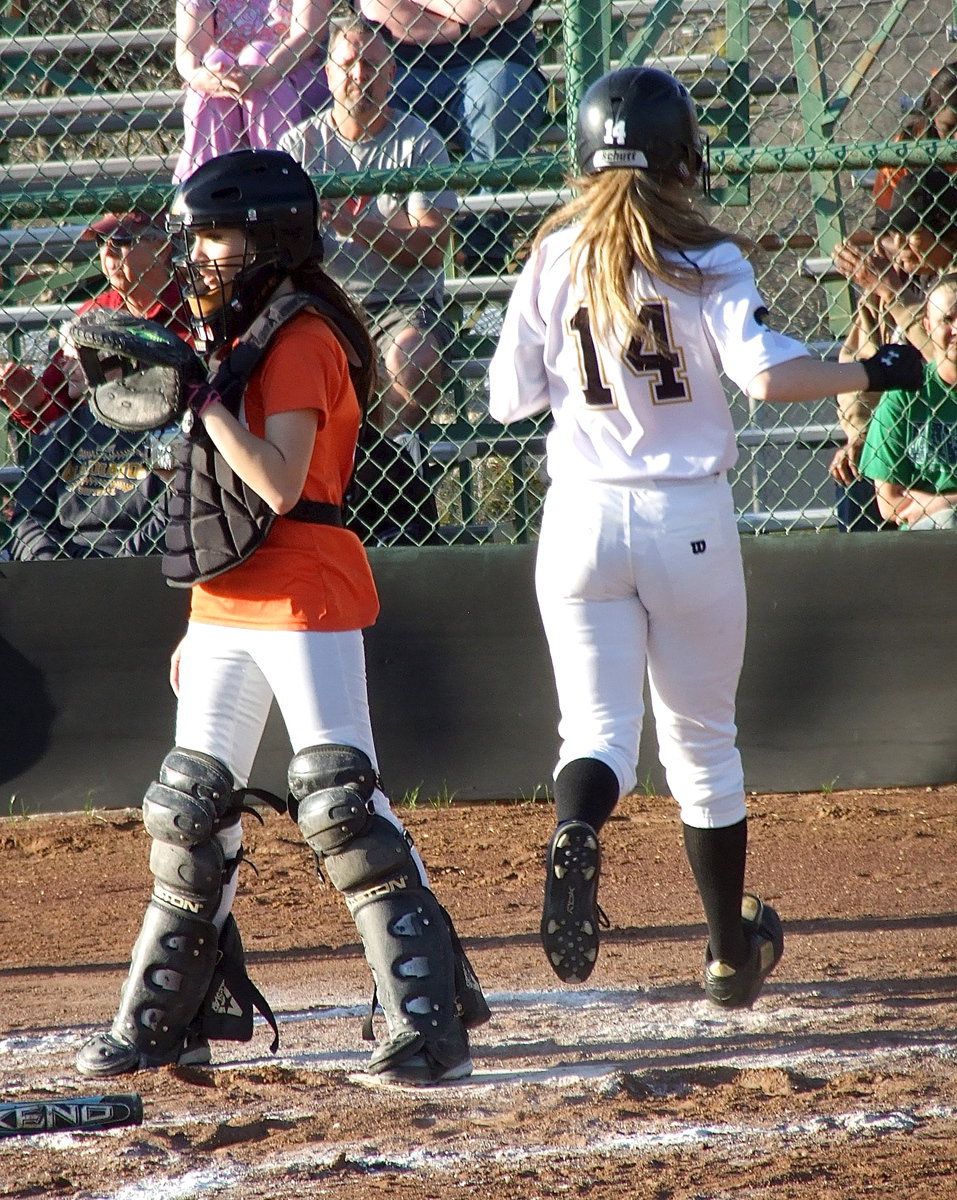 Image: Italy’s Kelsey Nelson(14) reaches home plate.