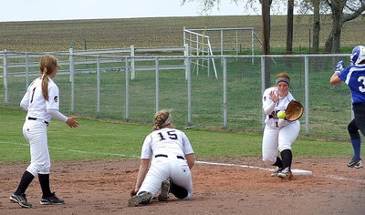 Image: Covering a wicked little grounder is pitcher Jaclynn Lewis who flips the ball over to first baseman Katie Byers(13) for the just-in-time out.