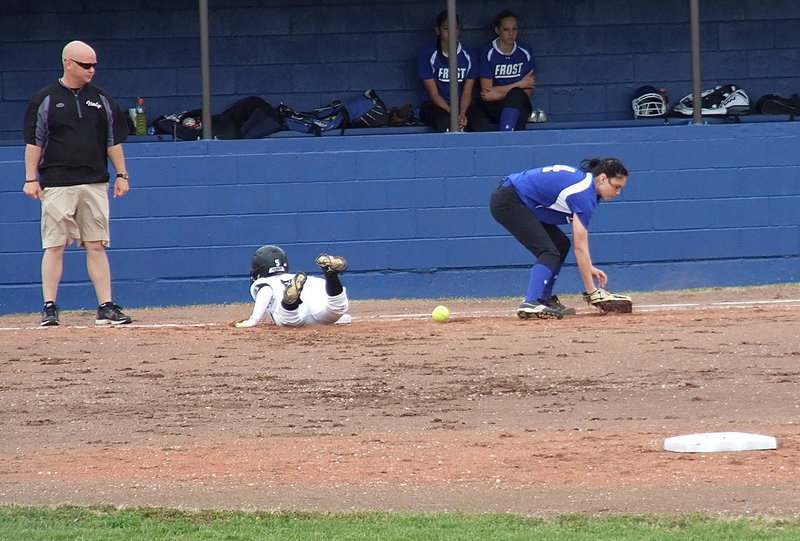 Image: Italy’s Tara Wallis(5) safely dives back to first base.