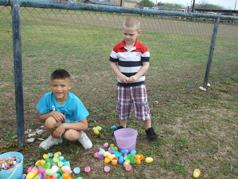 Image: Hayden Ellis and Matthew Cook are looking for the best egg in their baskets.  Matthew is 4 and Hayden is 7.