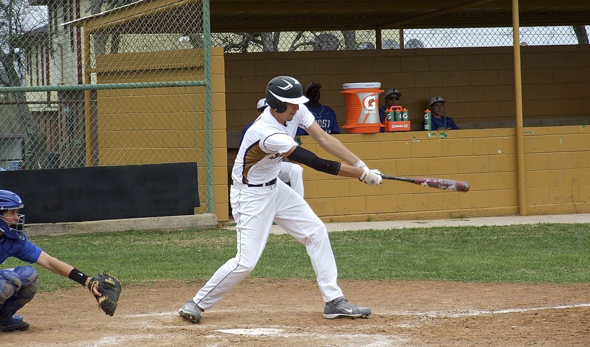 Image: Italy’s Cole Hopkins connects on a pitch to reach first base.