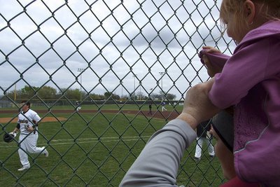 Image: Kenzie Purdue cheers on her uncle John Byers(18) while sitting atop the shoulders of aunt Katie Byers who plays first base for the Lady Gladiators.
