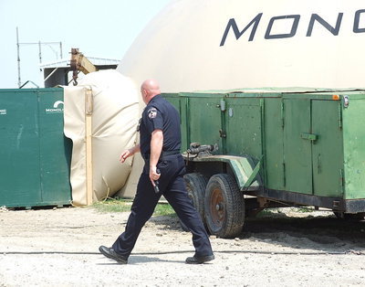 Image: Italy Police Chief Diron Hill has his sidearm drawn as the search for a suspect on the run continues at the headquarters of Monolithic Constructors, Inc. in Italy.