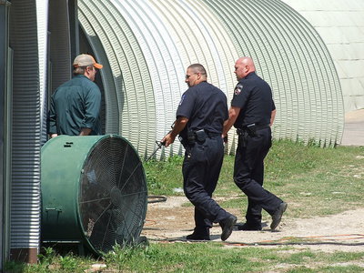 Image: Mike South opens doors to various property locations as Milford Police Chief Carlos Phoenix and Italy Police Chief Diron Hill conduct a dome-to-dome search.