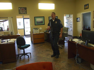 Image: Conducting an interior search of Monolithic’s main office is Milford Police Chief Carlos Phoenix.