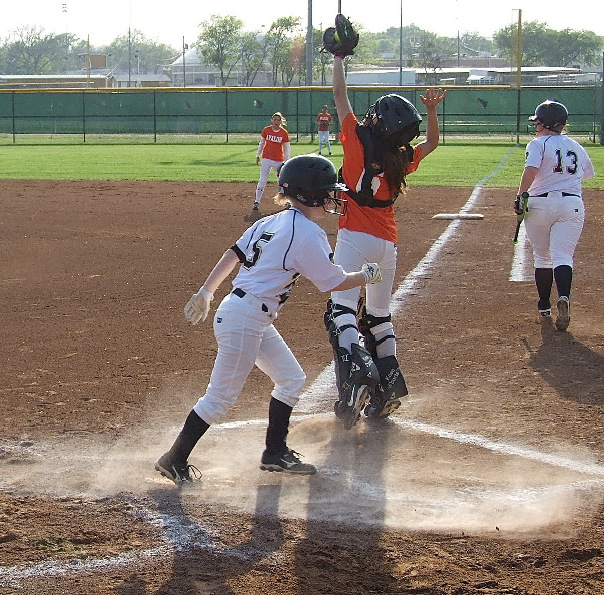 Image: Katie Byers(13) scores followed by Tara Wallis(5) who slides in to beat the throw to home.