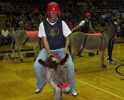 Image: Caden Jacinto hangs on while trying to steer his stubborn donkey.