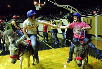 Image: Madison Washington and Tara Wallis celebrate their team’s success as the Arse-Kickers get the overtime win to win the donkey basketball tournament.