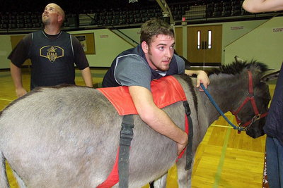 Image: After a few minutes, Zack Boykin is super tired after participating in donkey basketball as Hank Hollywood, the coach of Hollywood’s Heroes, checks the scoreboard.