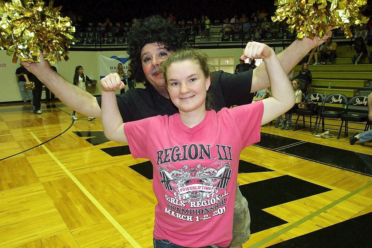 Image: Tara Wallis is pumped up over some donkey basketball as cheerleader Larry Eubank atomic bombs the photo.