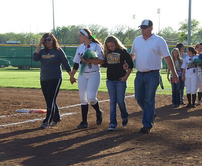 Image: Senior Alyssa Richards(9) is escorted onto the field by her mother Tina Richards, sister Brycelin Richards and father Allen Richards.
