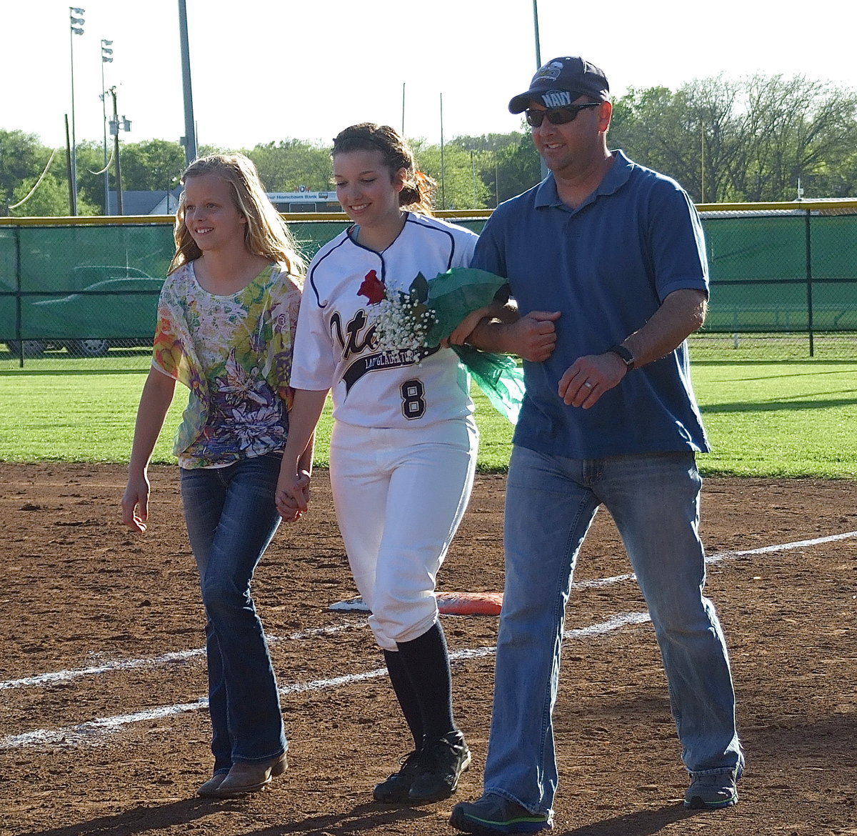 Image: Senior Morgan Cockerham(8) is escorted by her litlle sister Alex Jones an father Paul Cockerham.