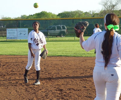 Image: Freshman K’Breona Davis(11) throws to Alyssa Richards(9) at first base during warmups in game 2.