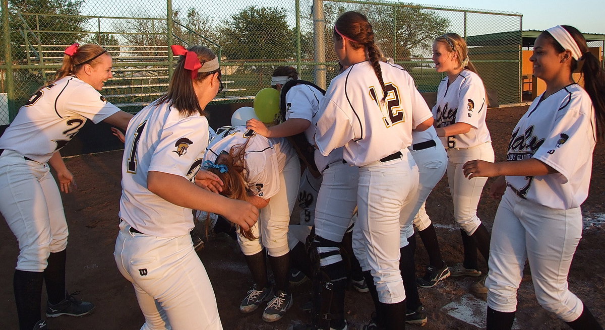 Image: Seniors Alyssa Richards, Morgan Cockerham and Katie Byers are mobbed by temmates to conclude the their final walk of the last district home game as senior Lady Gladiators.