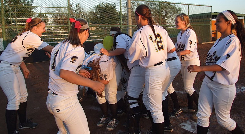 Image: Seniors Alyssa Richards, Morgan Cockerham and Katie Byers are mobbed by temmates to conclude the their final walk of the last district home game as senior Lady Gladiators.