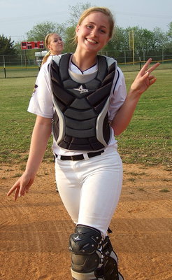 Image: Madison Washington(2) likes her new look as catcher. Photo bomb courtesy of teammate Jaclynn Lewis(15).
