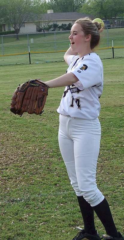 Image: Sophomore Kelsey Nelson(14) warms up with her teammates between innings.
