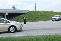Image: Milford Police Chief Carlos Phoenix directs traffic away from the 386 on ramp along Highway 35 North where traffic has been blocked due to a tractor-trailer fire.