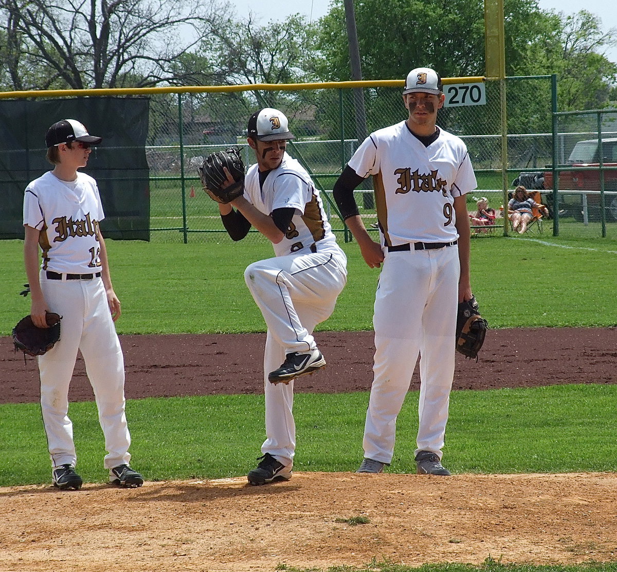 Image: Ty Windham(13), who takes over at second base, along with first baseman Cole Hopkins(9) meet at the mound to support Caden Jacinto(2) after a pitching change.