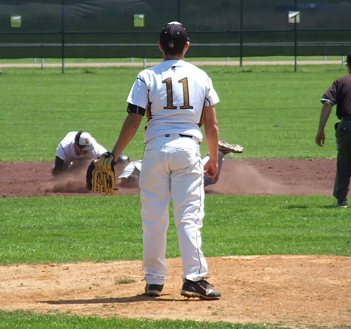 Image: Italy pitcher Tyler Anderson(11) looks on as second baseman Reid Jacinto(5) goes for the tag against a base stealing Bulldog.