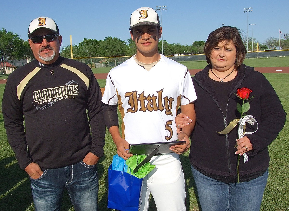 Image: Senior Reid Jacinto(5) is escorted by his parents Mark and Susan Jacinto.