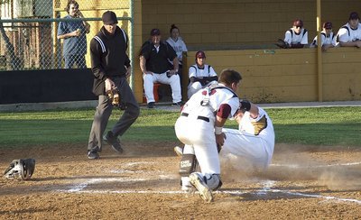 Image: Sophomore John Byers(18) slides safely into home beating the throw.