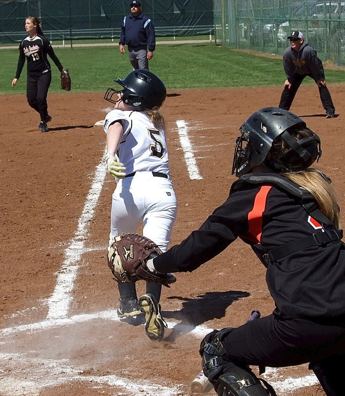 Image: Italy’s Tara Wallis(5) connects on the ball and then hurries down the first base line.