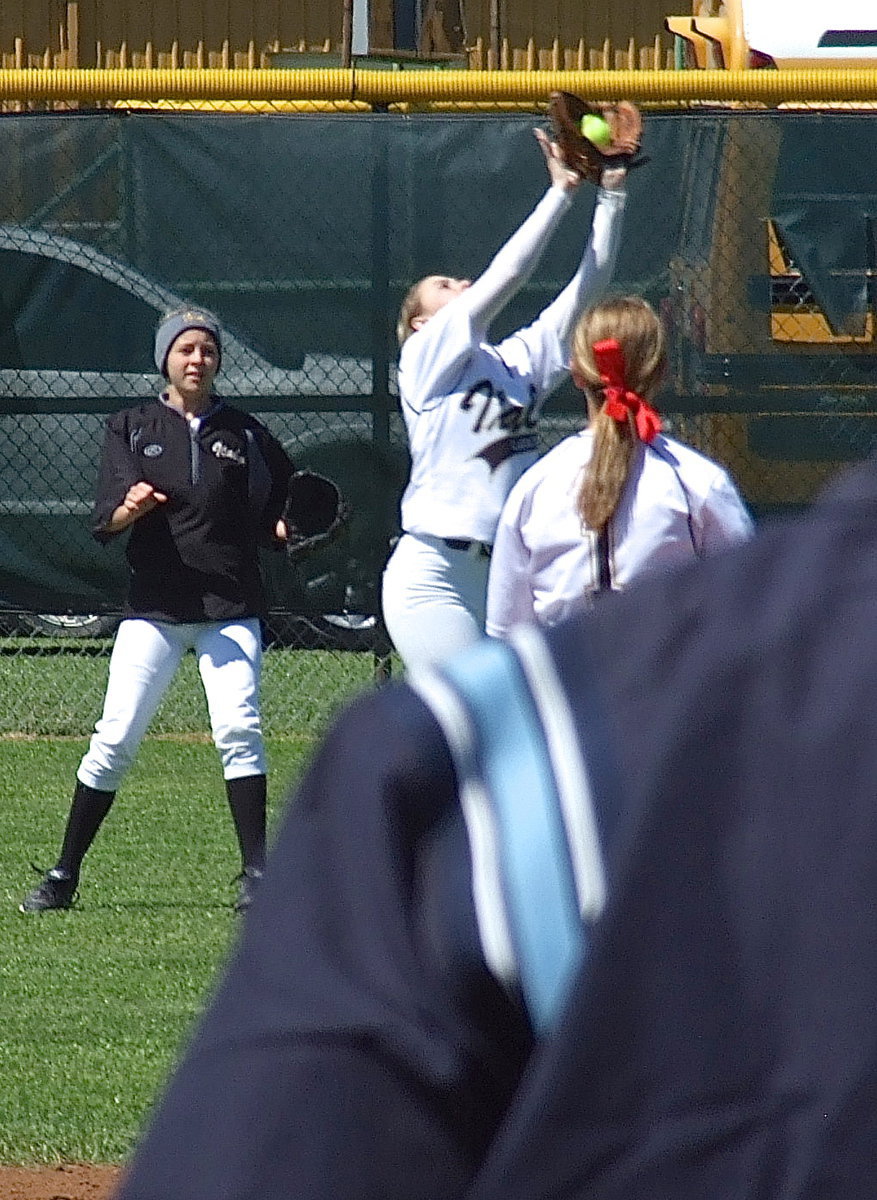 Image: Center fielder Kelsey Nelson(14) catches a fly ball in the shallow right field gap as Britney Chambers(4) and Bailey Eubank(1) back her up.