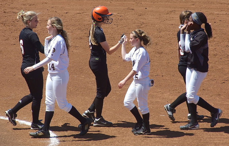 Image: Kelsey Nelson(14), Tara Wallis(5) and K’Breona Davis(11) display sportsmanship after defeating Ferris.