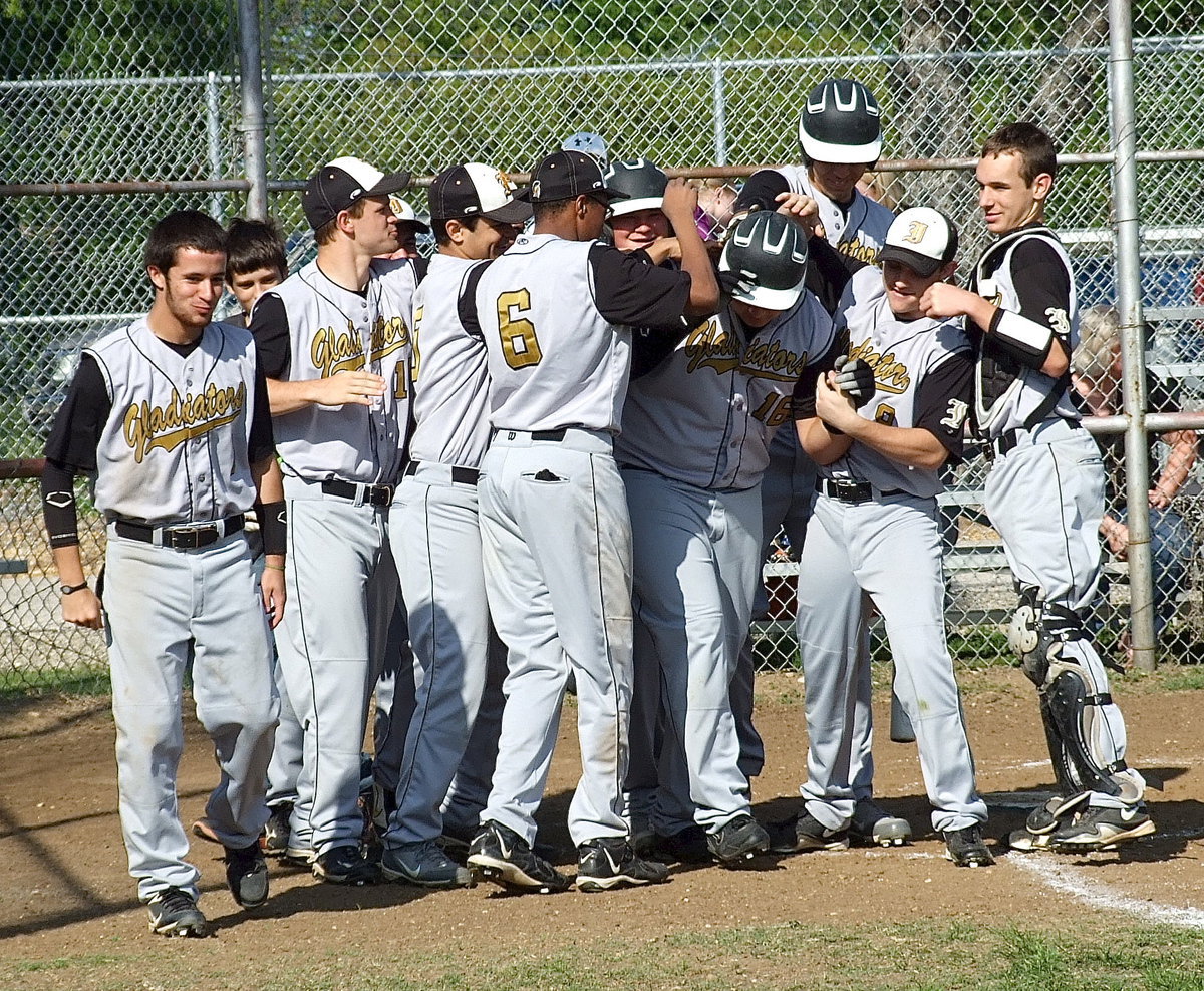 Image: Way to go, Kev! Kevin Roldan(16) is congratulated by his teammates after his mega hit.