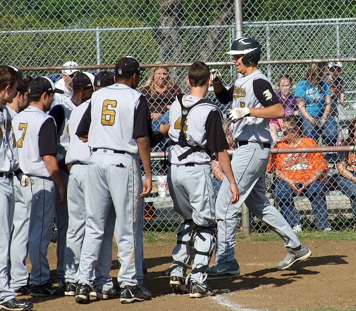 Image: Cole Hopkins(9) is greeted by teammates as he steps on home plate after hitting the third homerun in a back-to-back-to-back homerun bonanza by Italy.