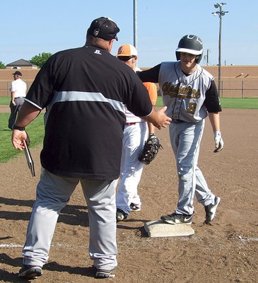 Image: Coach Brian Coffman congratulates Hayden Woods(8) on joining the party at first base.