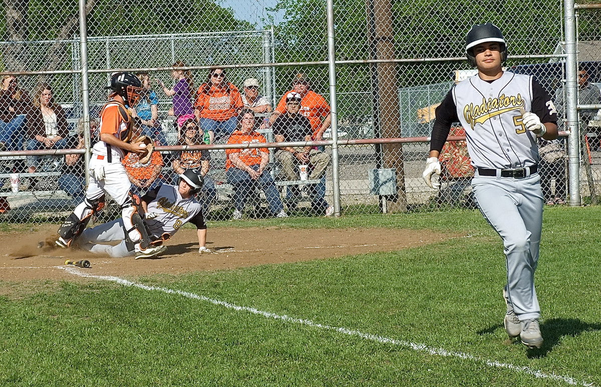 Image: Avalon catcher Blake McCulloch(12) catches a 3rd out popup hit by Italy’s Reid Jacinto(5) to keep the sliding Hayden Woods(8) from scoring another run for the Gladiators.