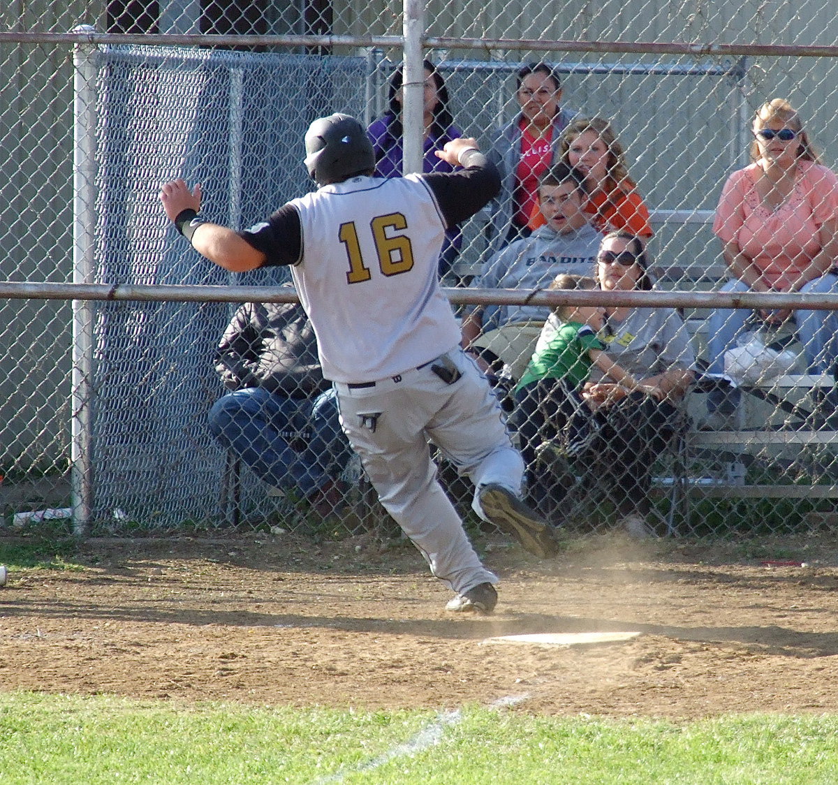 Image: Kevin Roldan(16) tries to put on the breaks after scoring a run for Italy.