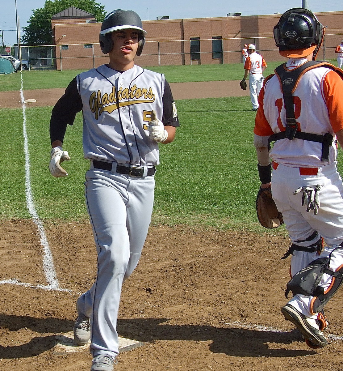 Image: Italy’s Reid Jacinto(5) crosses home plate.