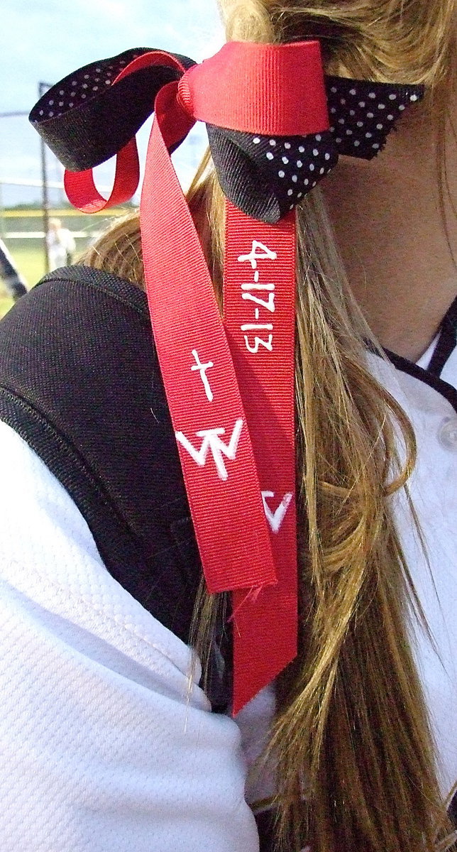 Image: The Italy Lady Gladiators remember the community of West, where a recent fertilizer plant explosion devastated much of the area, by wearing red ribbons decorated by Sandy Eubank who works at Italy’s Uptown Cafe, a big supporter of Italy Athletics as well as the community as a whole. The ribbons display a cross, the date of the tragedy 4-17-13 and the initials, “W.T.” for West, Texas.