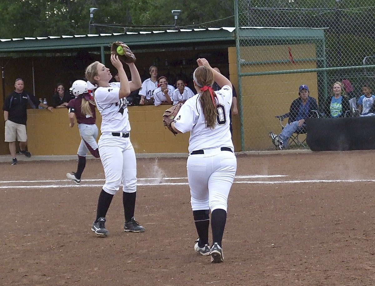 Image: Italy’s Jaclynn Lewis(15) pulls in a pop-up in front of the mound with third baseman Paige Westbook(10) signaling the ball’s location.