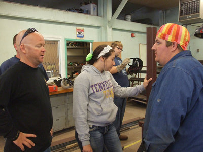 Image: Michael Chambers asks Mr. Godwin about some angle iron with holes for a project he is working on.