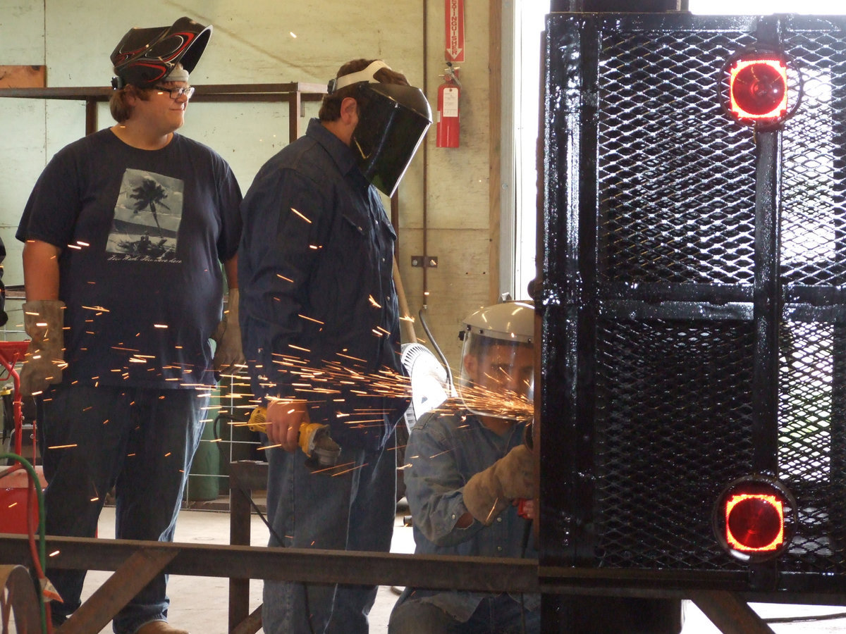 Image: Logan and Kevin watch Cody grind down the old axle.