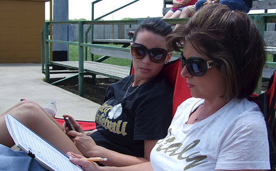 Image: Cassi Windham checks the stats being kept by her mother, Andrea Windham, who is also the mother of Italy’s JV Baseball pitcher, Ty Windham.