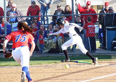 Image: Italy’s Britney Chambers(4) hits and then hustles to first base.