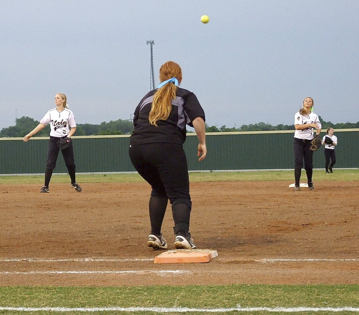 Image: Italy infielders Madison Washington(2), Katie Byers(13) and Bailey Eubank(1) warm up.